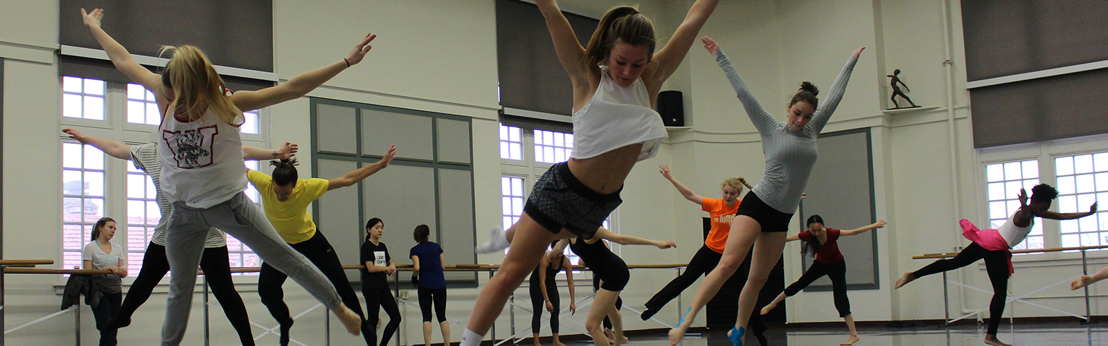 dancers in studio moving with arms raised